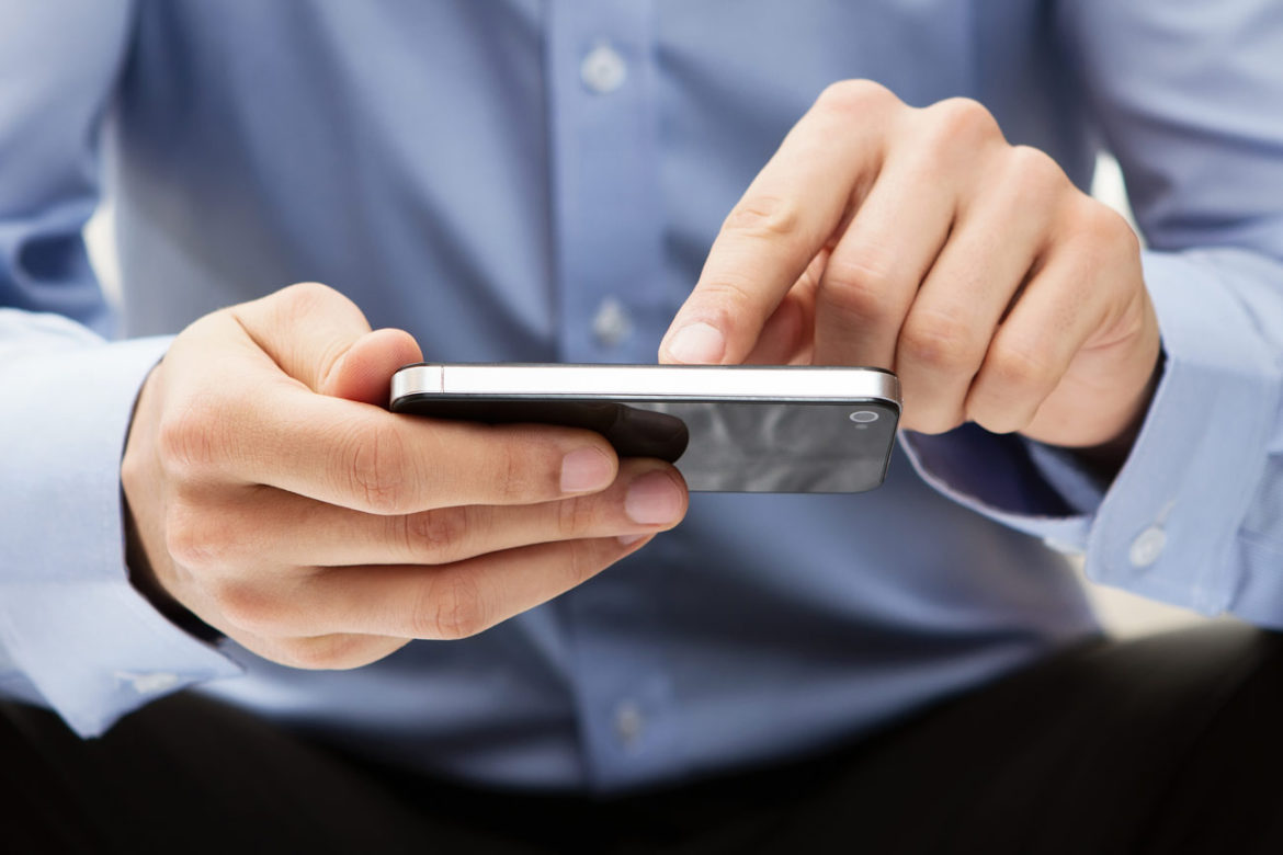 Person im blauen Hemd tippt auf ein Smartphone – mobile Daten überall nutzen